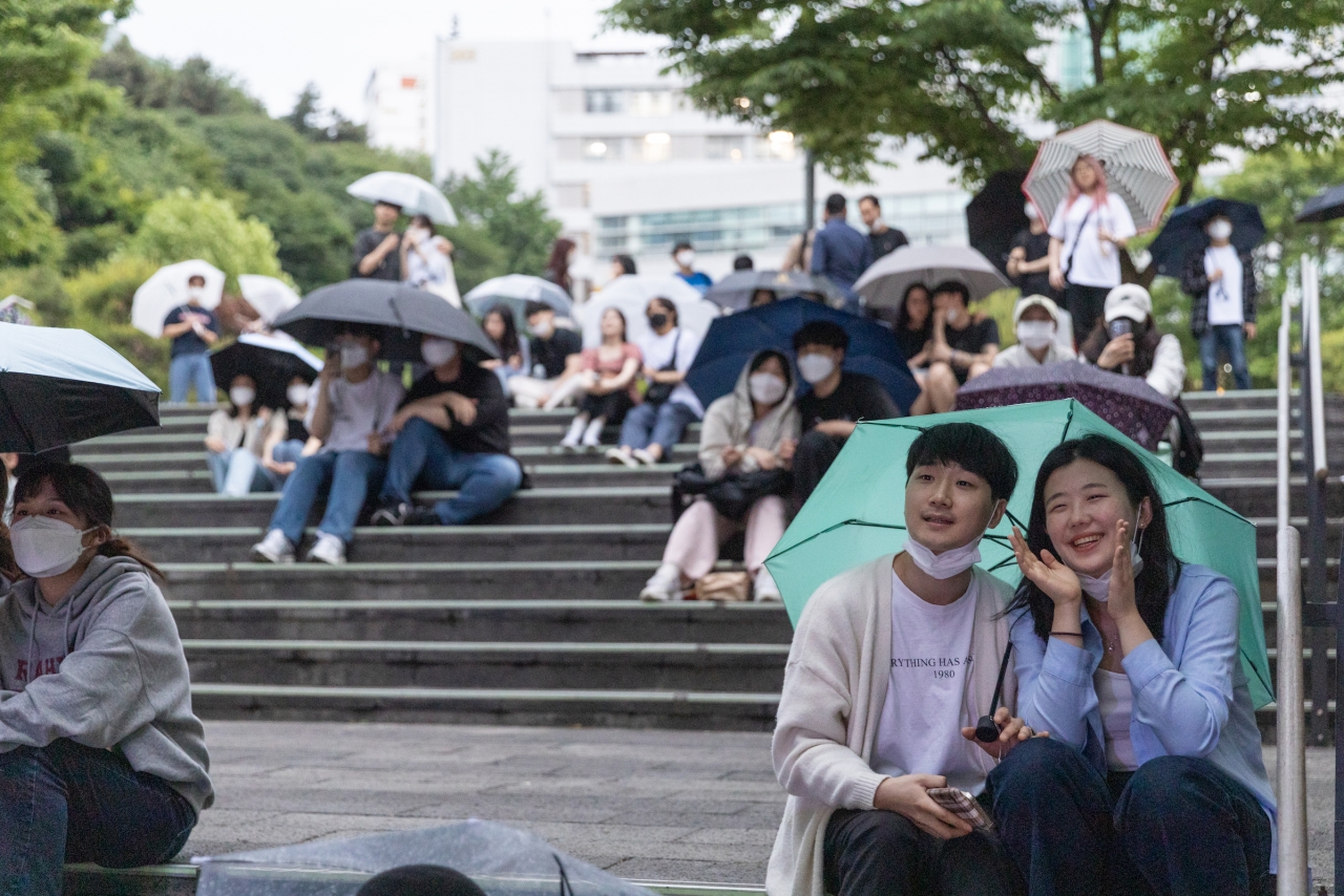25일 토크콘서트 ONCE를 진행하던 중 비가 내리자 관객들은 우산을 나눠 쓰고 빗속의 낭만을 즐겼습니다. 사진 김수현 기자