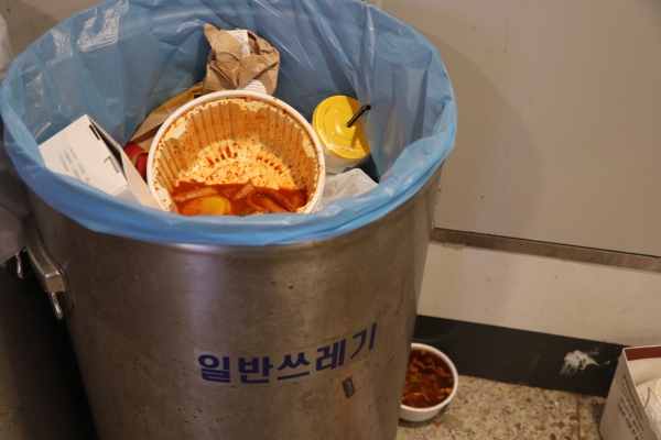 107관 일반 쓰레기통에 배달 음식 용기가 버려져 있다. 용기 안에는 음식물 쓰레기가 그대로 담겨 있었다.사진 홍예원 기자